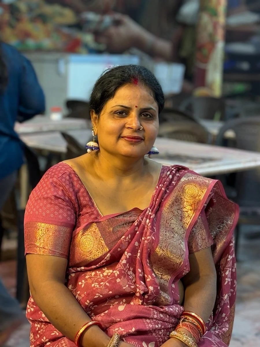 Elegant woman in a rose and gold saree, seated portrait